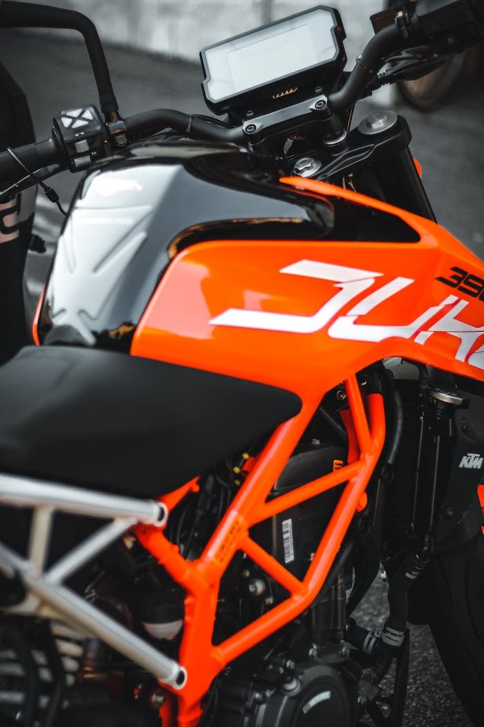 Close-up of a modern orange motorcycle showcasing its sleek design and vibrant color.